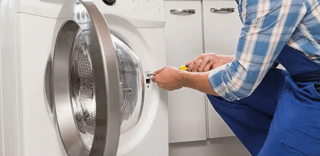 Handyman repairing a clothes dryer and checking electrical connections in Santa Ana, CA