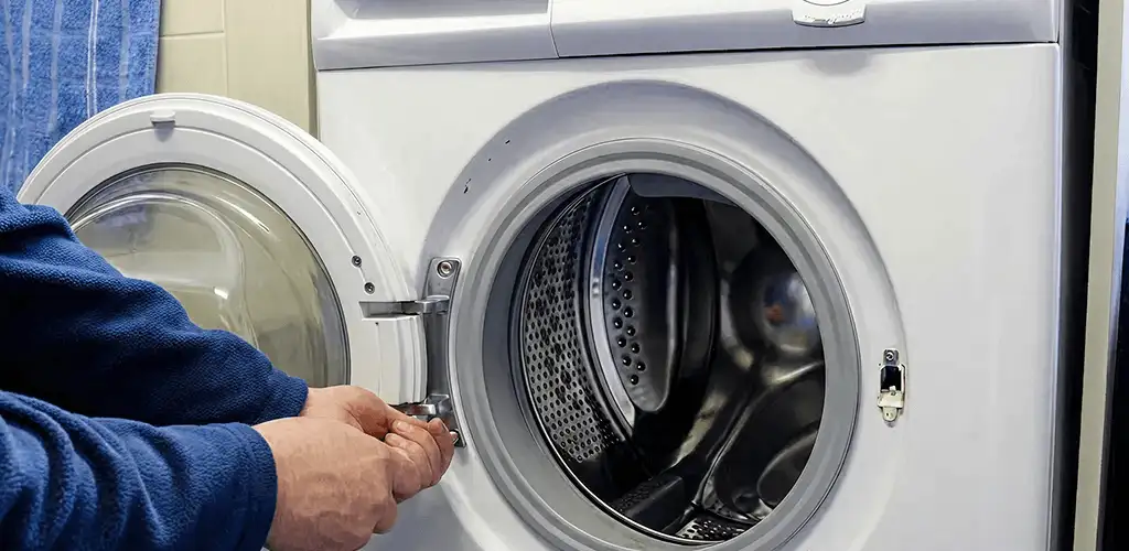 Washing machine repair handyman checking a front-load washer door and latch in Santa Ana, CA