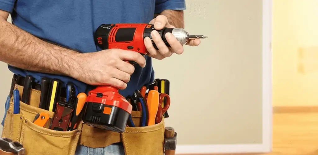 Handyman holding a power drill for home repairs and installations in Santa Ana, CA