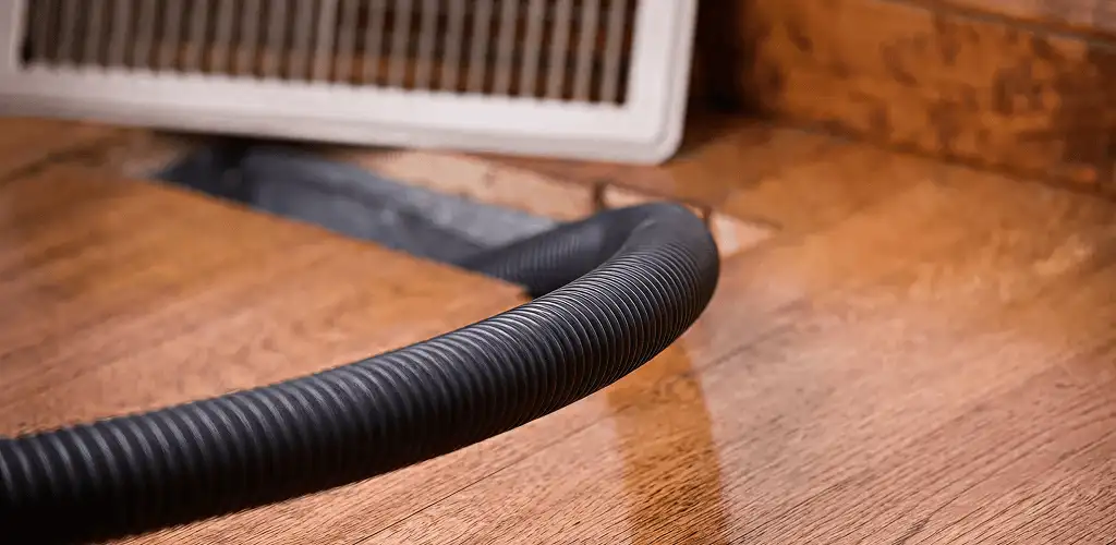Air duct cleaning hose inserted into a floor vent for ductwork cleaning in Santa Ana, CA